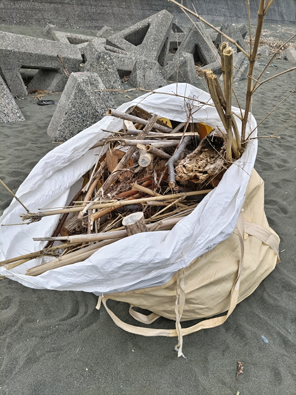 引籠りニートだった齋藤健一が袋に入れた流木の山を見ているところ【大磯町の吉田邸前の海岸にて】