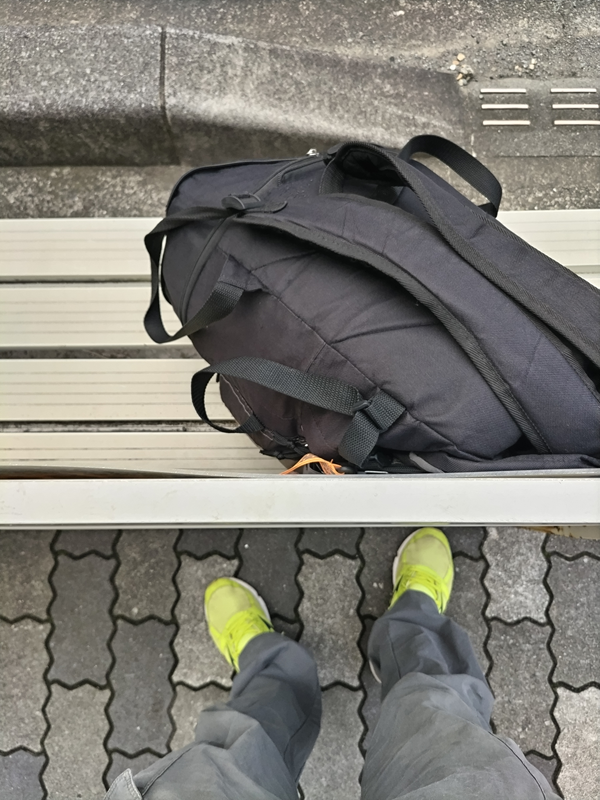 引籠りニートだった齋藤健一が黒い自分のリュックを白いベンチに置いた時の様子