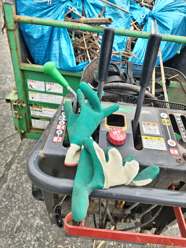 元ニート引籠りの齋藤健一がキャリアダンプの操作パネルの上に置いた作業用手袋を見ているところ