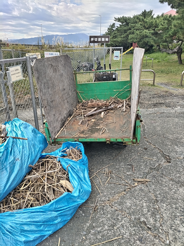 元ニート引籠りだった齋藤健一が海岸清掃で使っていたキャリアダンプと、その手前にある大量の木くずゴミが包まれた青いビニールシート