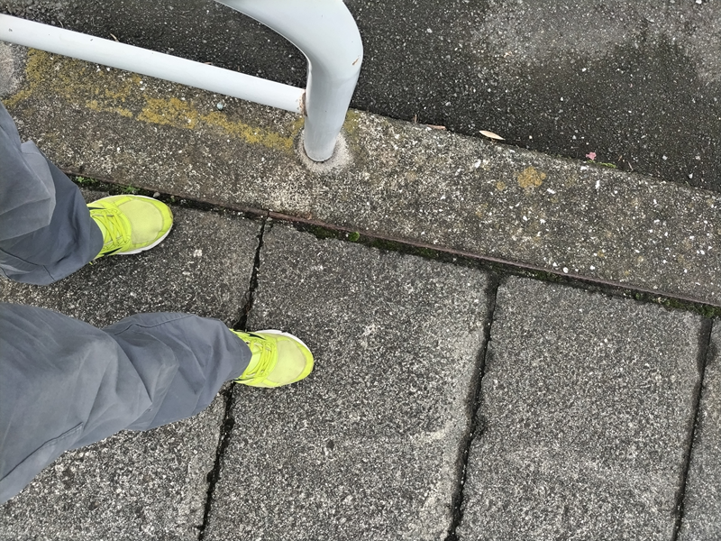 元ニート引籠りの齋藤健一が黄色いスニーカーを履いて石畳の歩道を歩いている様子