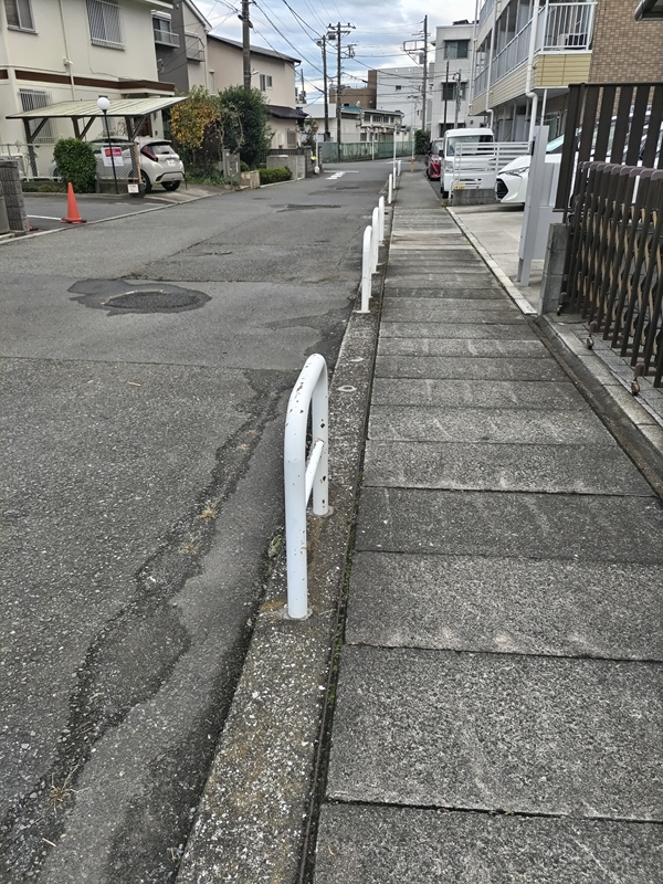 引籠りニートだった齋藤健一が白い柵の中の歩道を歩いている様子