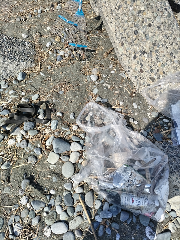 引籠りニートだった齋藤健一が二宮町の押切海岸に置かれたビニール袋と熊手を見ているところ