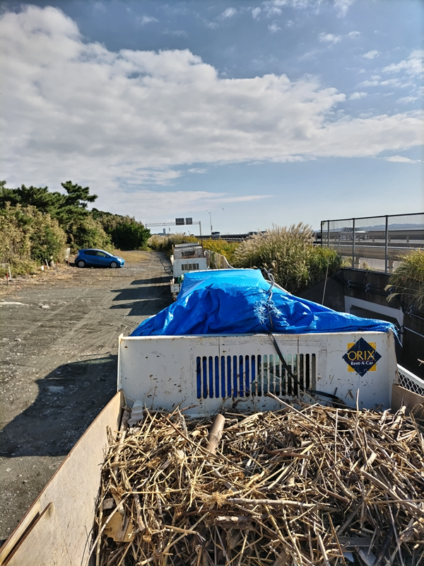 引籠りニートだった齋藤健一が押切海岸上の駐車場に停めたトラックの荷台から木くずゴミを見ているところ