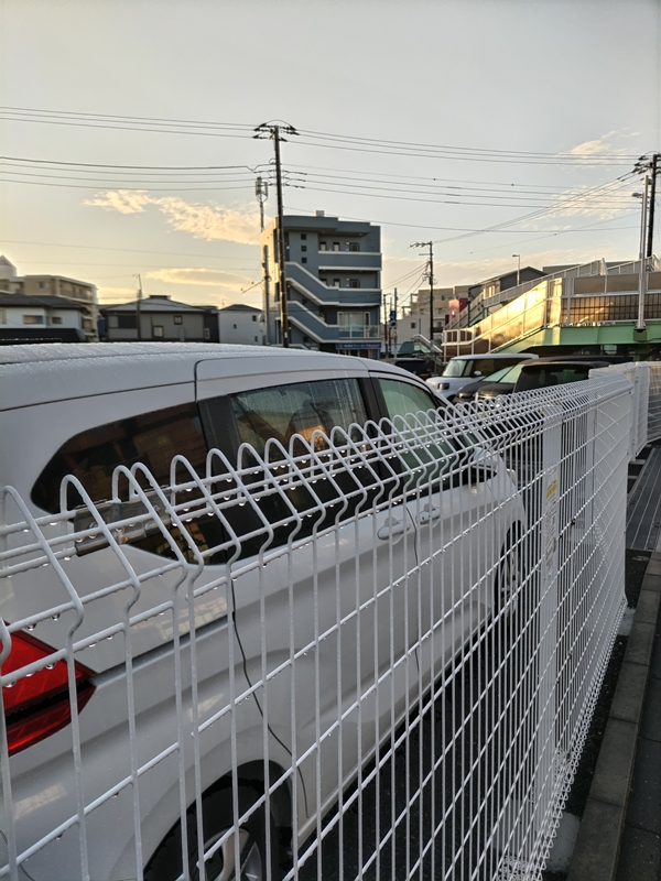 歩道から柵を挟んで見える白いホンダ車を見ていた元ニートの齋藤健一