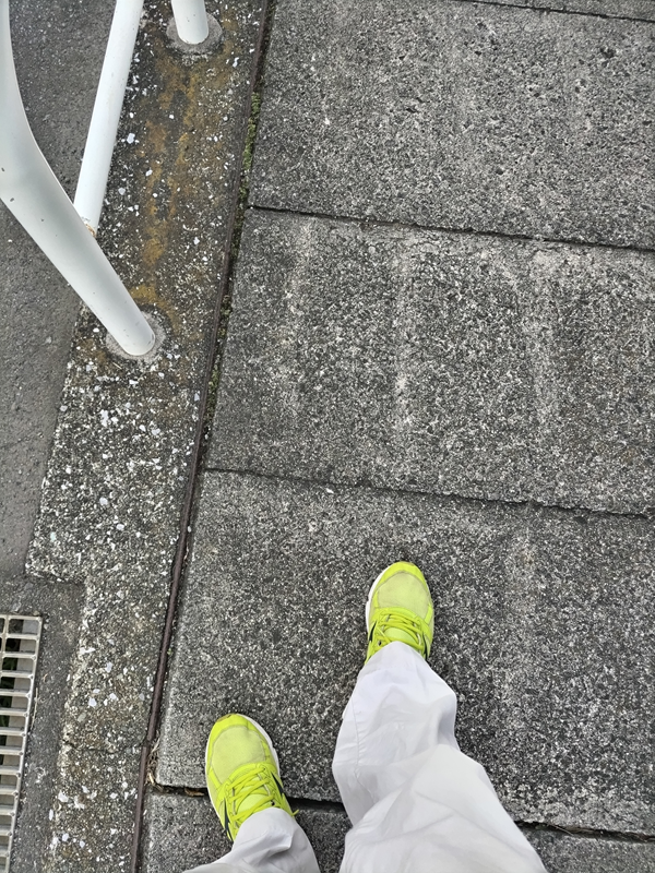 元引籠りニートが黄色いスニーカーと白い作業ズボンで立っていたコンクリートの地面