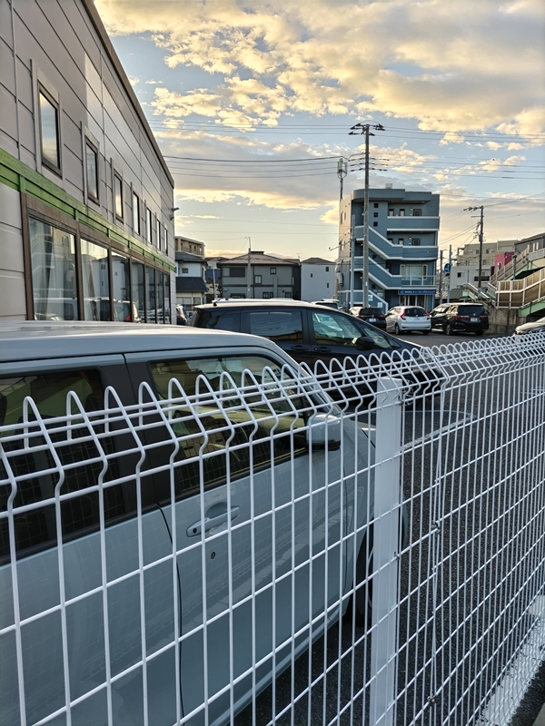 引籠りニートだった齋藤健一がホンダ車保管庫の前の白い柵を見ている様子