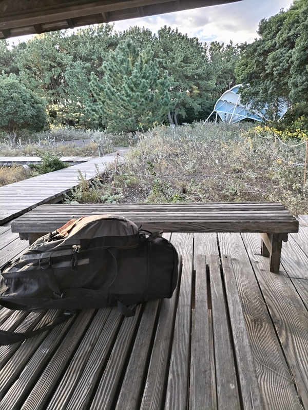 引籠りニートだった齋藤健一が木製テーブルの上に置いた黒いリュック