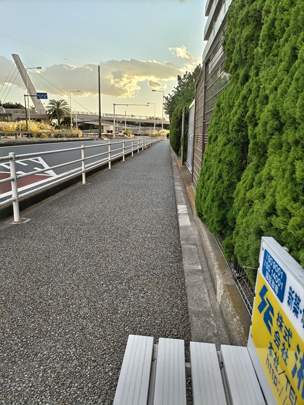 元ニート引籠りの齋藤健一が見ていた海へと続くバス停前の歩道と白いベンチ