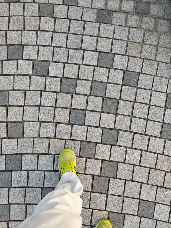 引籠りニートだったセル齋藤が黄色いスニーカーを履いてタイル張りの地面を歩いているところ