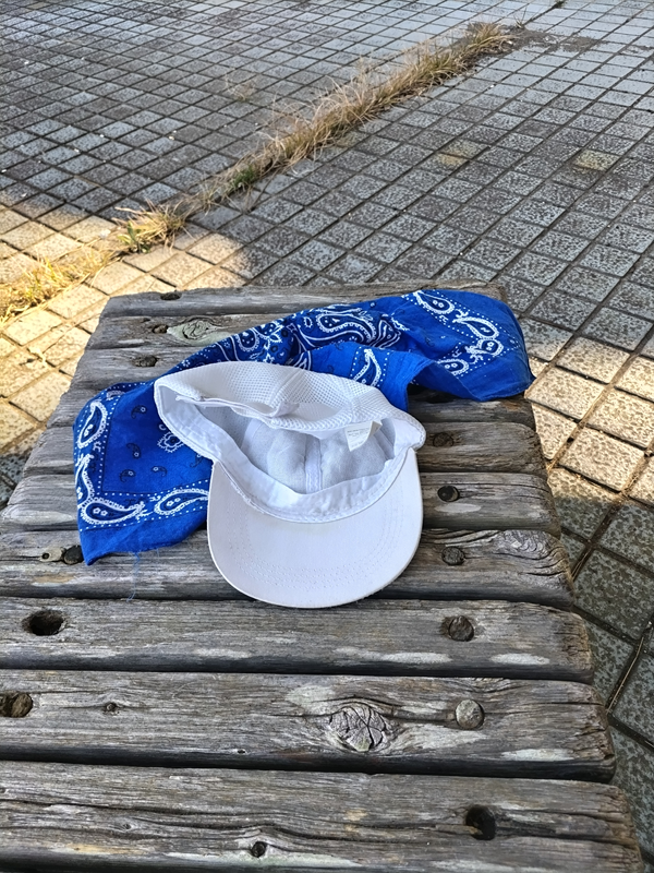 元ニート引籠りのセル齋藤が木製ベンチに置いた白い帽子と青いバンダナ