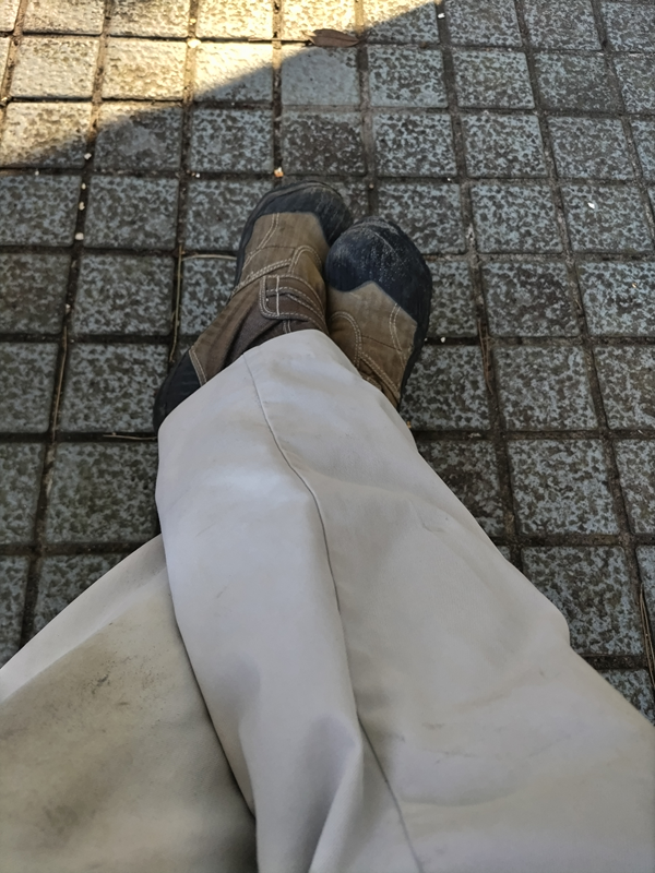 引籠りニートだったセル齋藤が昼の公園内で足を組んでいる様子