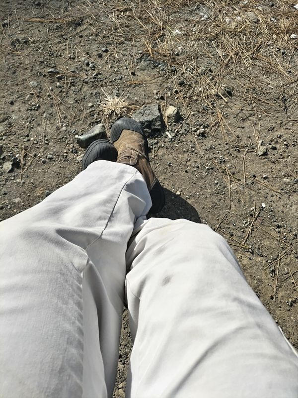 元ニートのセル齋藤が白い作業ズボンで足を組んでいる様子