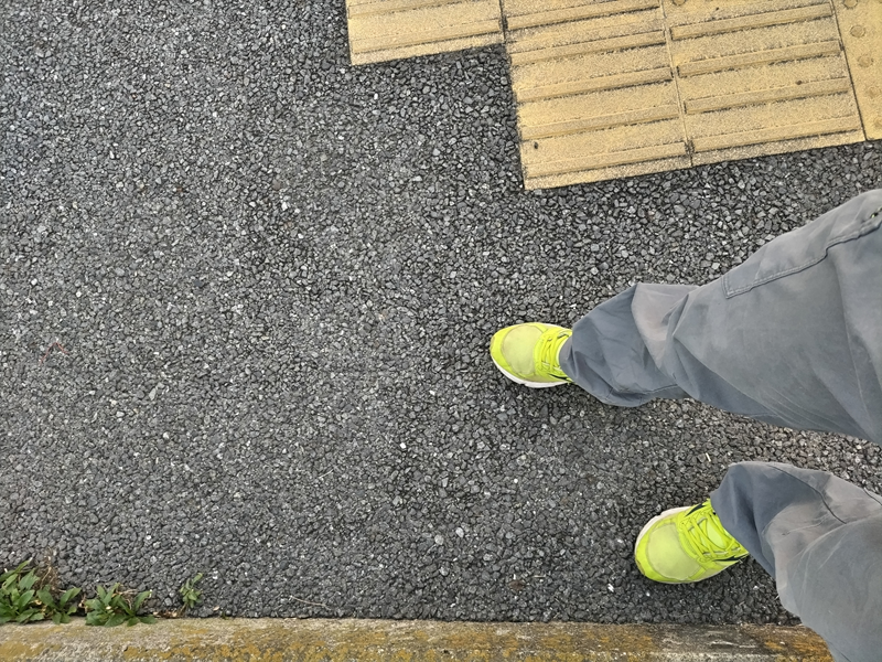 元引籠りニートがアスファルトの地面に黄色いスニーカーを履いて立っていた様子