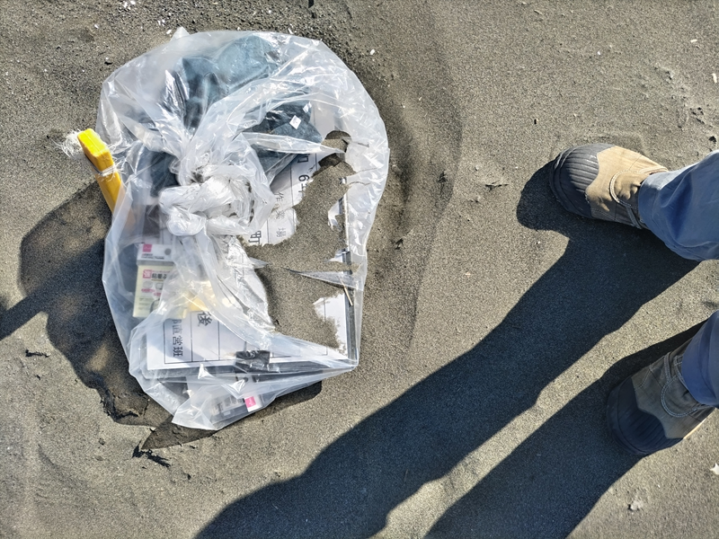 引籠りニートだった齋藤健一が黄色い杭と作業用看板を見ている様子【神奈川県の大磯町の大磯海水浴場にて】