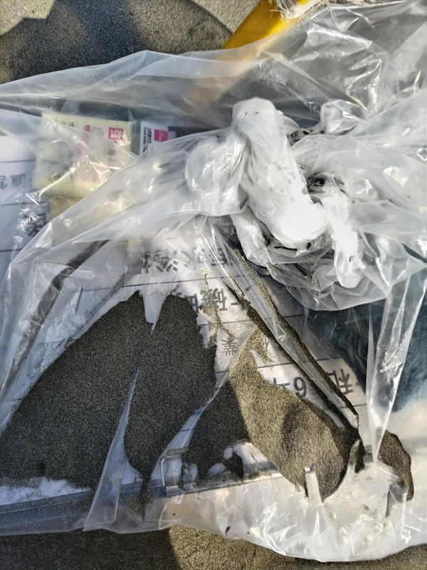 引籠りニートだった齋藤健一が大磯海水浴場に置かれて砂塗れになった仕事用の看板を見ている様子