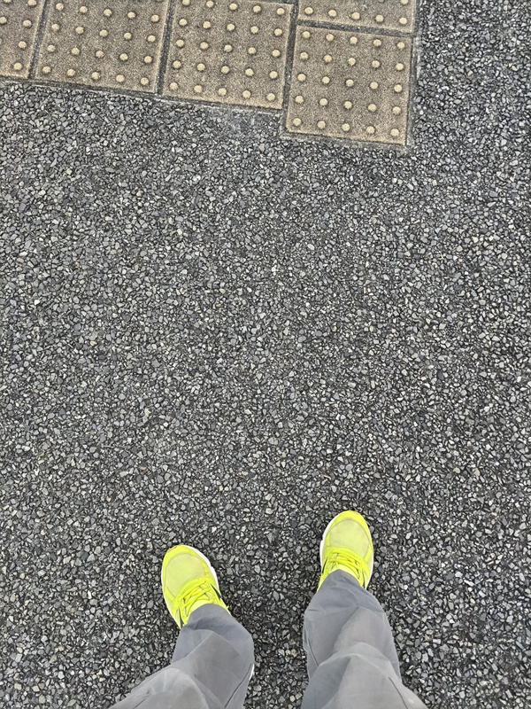 元ニート引籠りの齋藤健一が早朝の舗装された地面に立っている様子